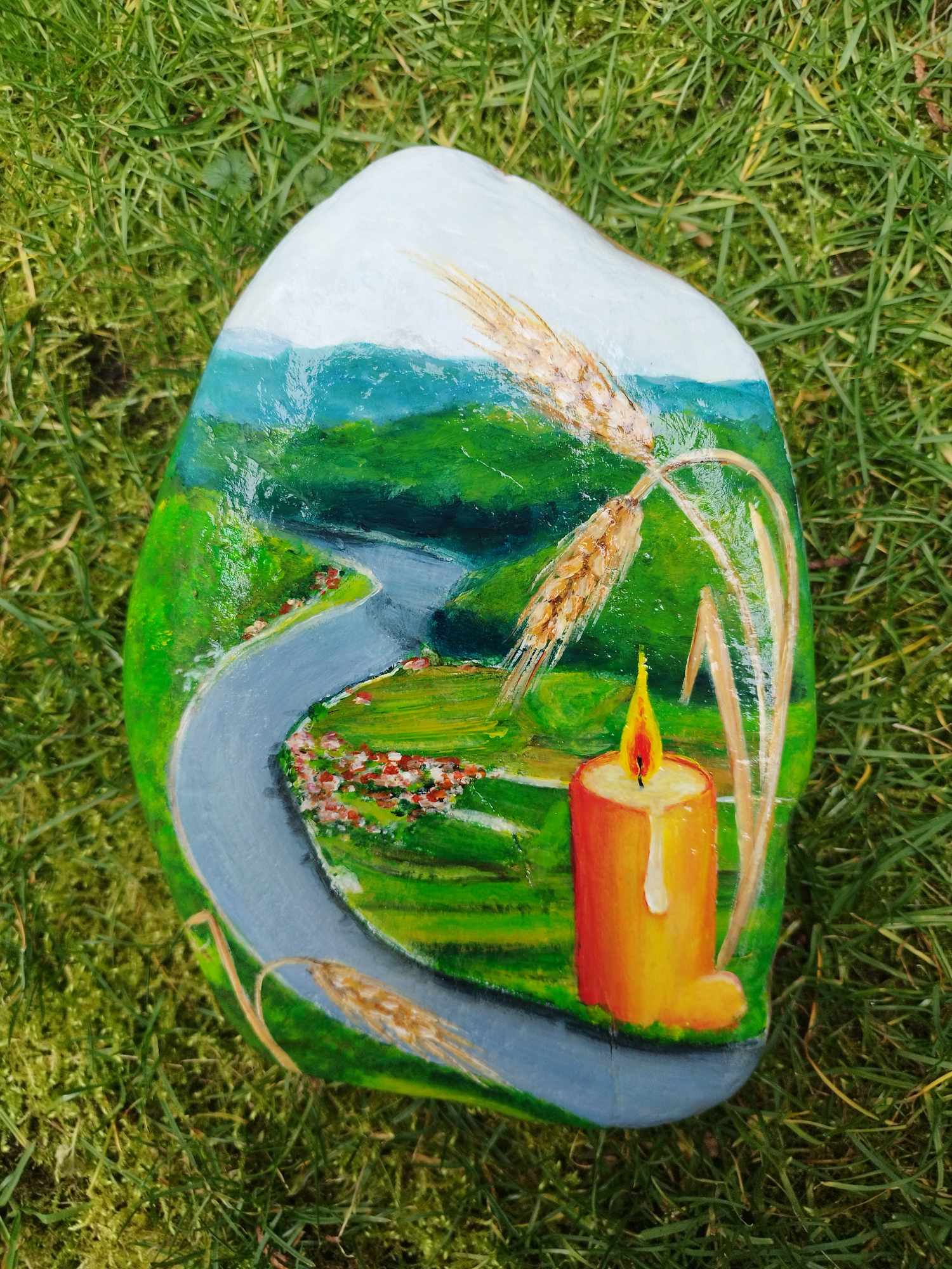 Vas kompolje naslikano na spominski kamen s svečko